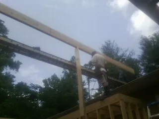 Carpenter setting a ridge beam over a new addition frame — Ice Dam Removal by Roofing Brothers in Frankford