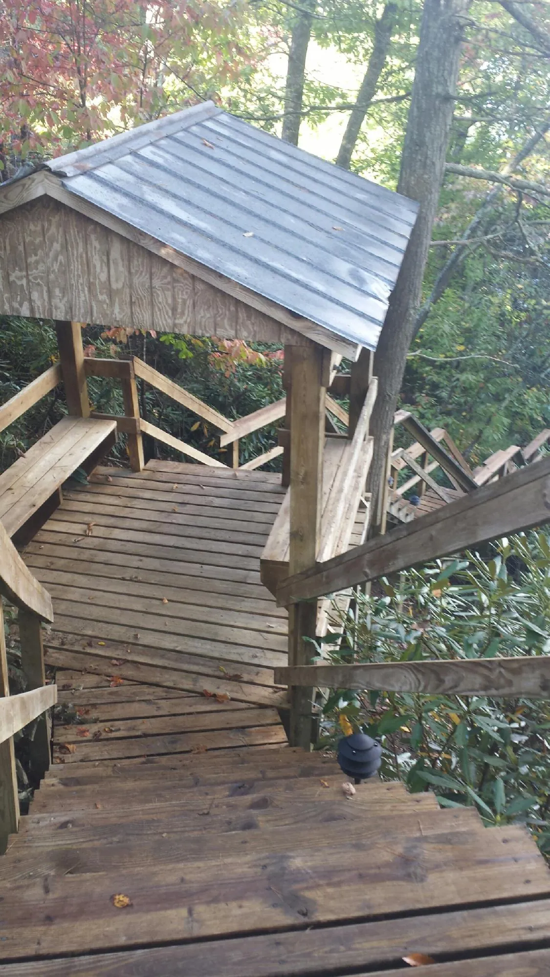 Metal roofed shelter over wooden steps on a wooded walkway — Skylight Repair & Installation work by our crew in Frankford